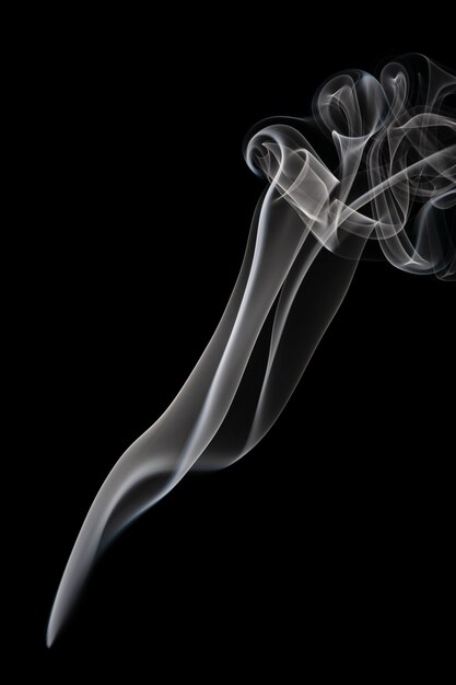 Abstract beautiful art. White smoke from the incense isolated on a black background. 
