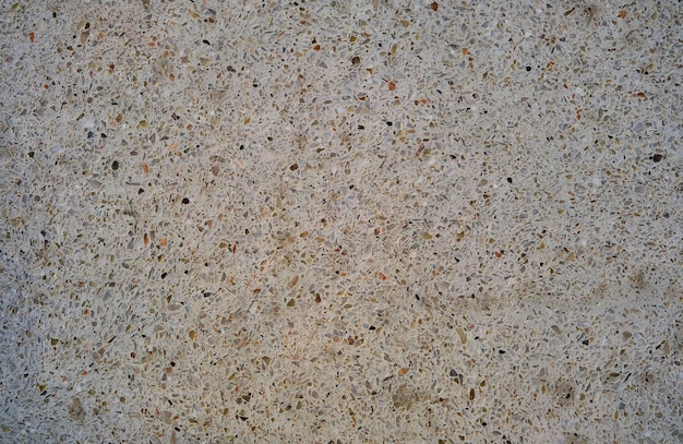 Abstract beige background interspersed with marble chips.