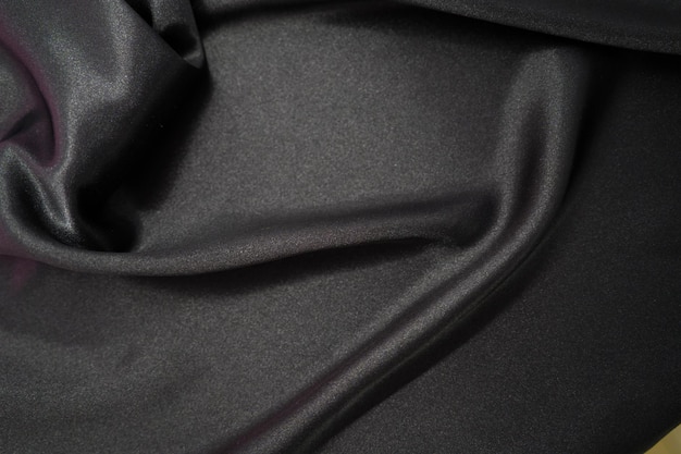 Abstract Black Satin Silky Cloth Fabric Textile Drape with Crease Wavy Folds background