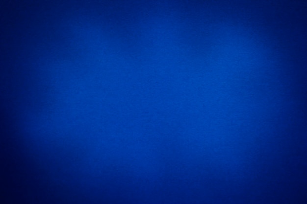 Photo abstract blue paper textured background with vignette and copy space paper texture