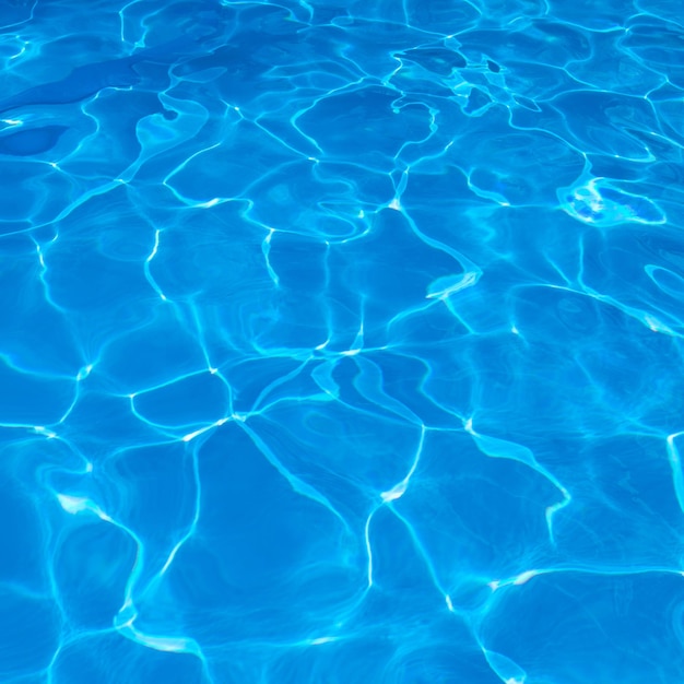 Abstract blue texture of swimming pool water with reflectionsxa