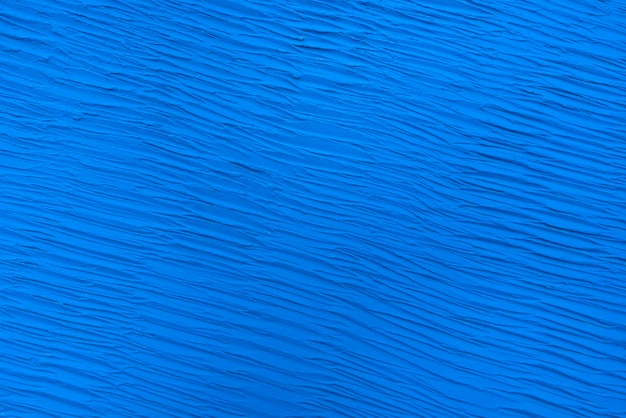 ざらざらした質感の抽象的な青。塗られたテクスチャ壁をクローズアップ。