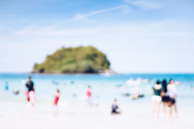 Priorità bassa astratta della sfuocatura della spiaggia e della gente che godono della spiaggia tropicale.