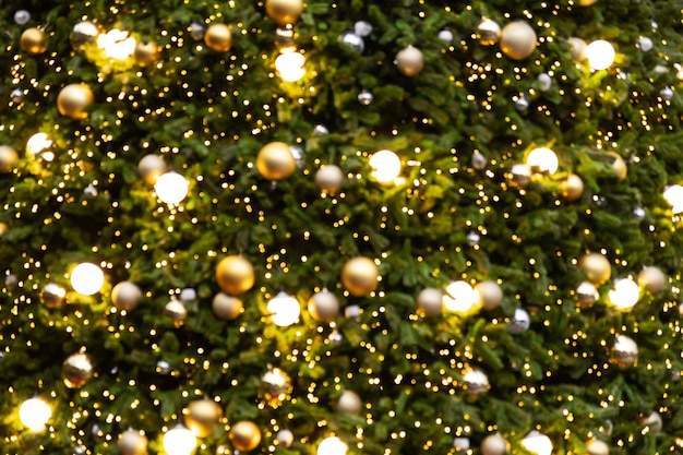 Foto sfocatura astratta dello sfondo dell'albero di natale vintage con decorazione a sfera - bokeh leggero dall'albero di natale alla festa notturna in inverno. tonalità di colore vintage