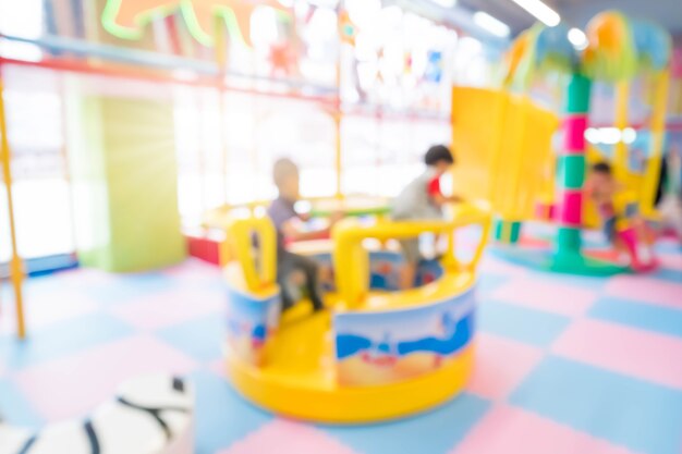 Abstract blur happy kids playing on slide, Indoor children playground.