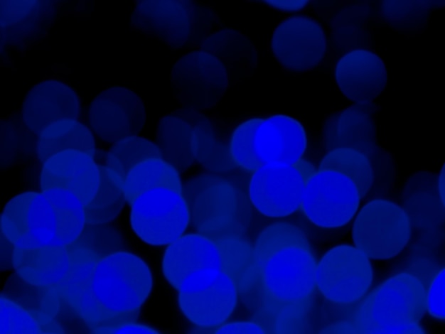 Abstract blur image of blue light of beautiful bokeh on black background Blurred festive night party and celebration bokeh background