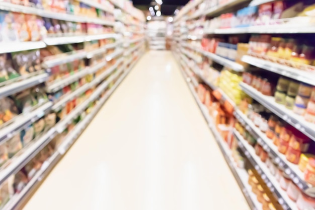 Abstract blur supermarket aisle with can food and snack product on shelves defocused background