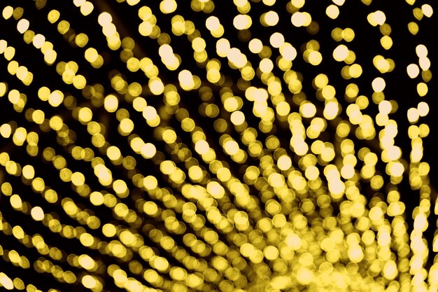 Abstract blurred background, golden yellow blurred lights Bokeh on black background, glittering circle pattern