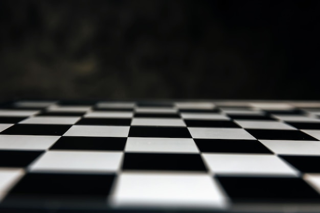 Abstract blurred black and white chess board game competition on dark background, chess battle, business management, leadership success, team leader, teamwork, business strategy planning concept