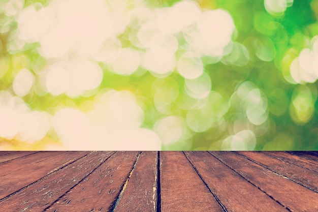abstract blurred green bokeh and wood table background with space.