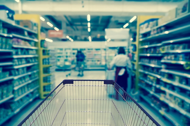 百貨店のbokehの背景のトロリーで店の抽象的なぼやけた写真