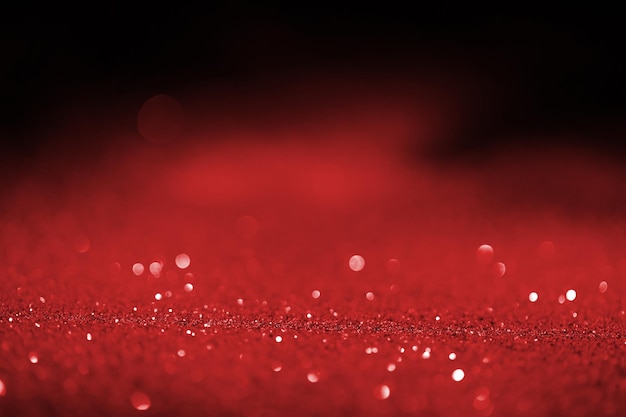 Photo abstract blurred red glitter on dark background