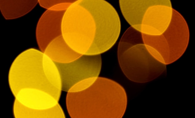 Abstract Blurred Vibrant Yellow and Orange Color Illuminated Light on Dark Background