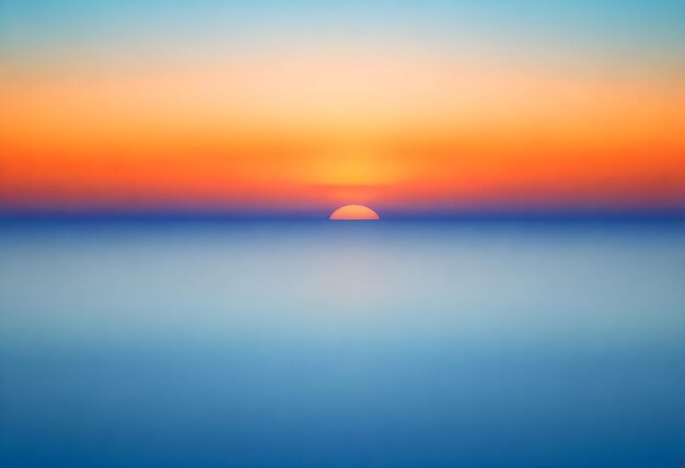 Foto vista astratta sfocata di un tramonto sopra l'oceano con gradienti di colori che vanno dal blu all'arancione