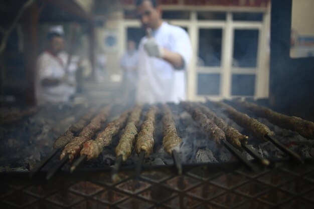 抽象的なぼやけた男の料理人は、バーベキュー、肉に火をつけます