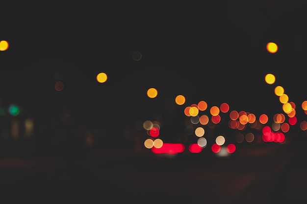 Abstract bokeh background of night street with car and street lamps. City life, defocused lights from cityscape, style color tone. Concept of abstract stylish urban backgrounds for design. Copy space