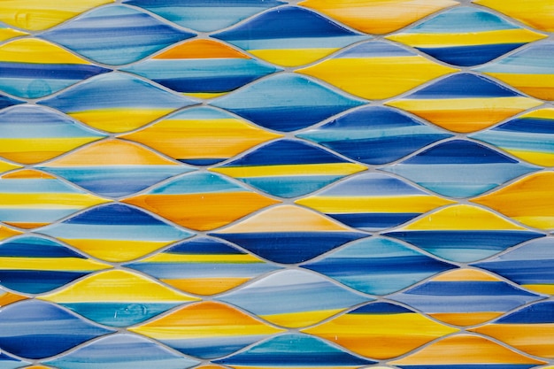 Sfondo astratto in ceramica motivi tradizionali italiani su piastrelle pittura artigianale a rombi ovali mosaico blu e giallo