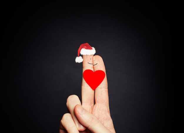 Abstract Christmas Couple Christmas Happy Face Fingers in Santa Hats on Blackboard Background