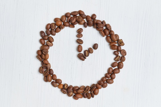 Abstract clock of coffee beans on a white background.