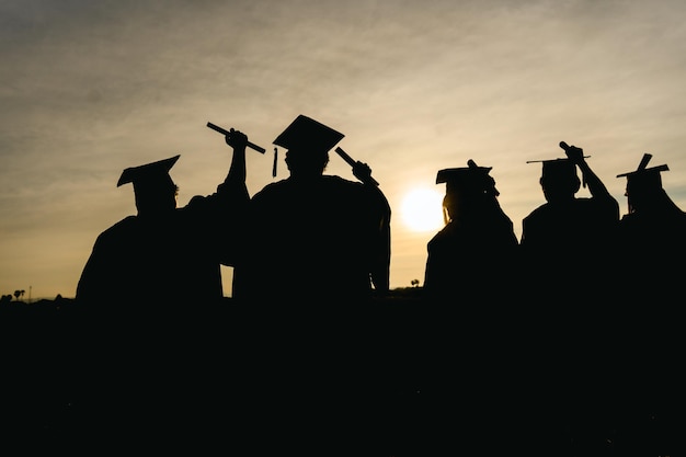 Photo abstract close up rear view group of the university graduates at silhouette sunset