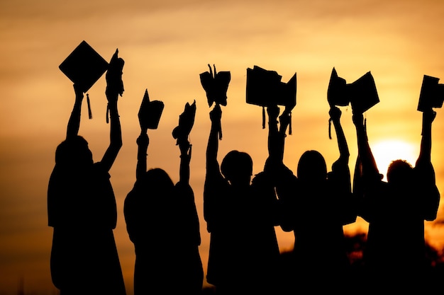 Photo abstract close up rear view group of the university graduates at silhouette sunset