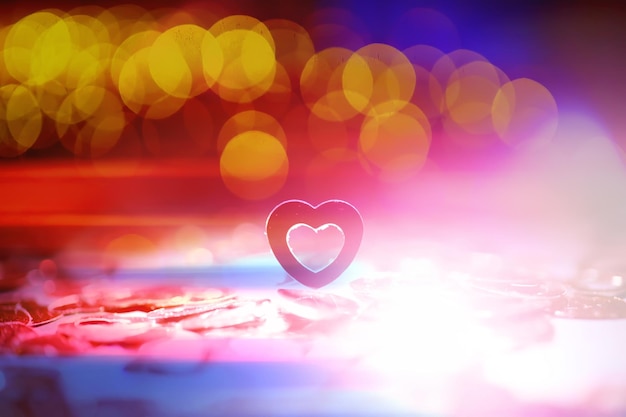 Abstract colored background Red toy in the shape of a heart on a glitter and bokeh background