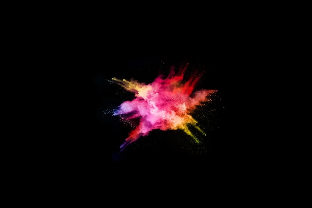 Фото Абстрактный цветной взрыв пыли на черном фоне.
