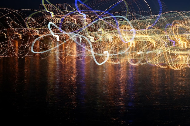 The abstract colored waves of illumination in the reflection over the water