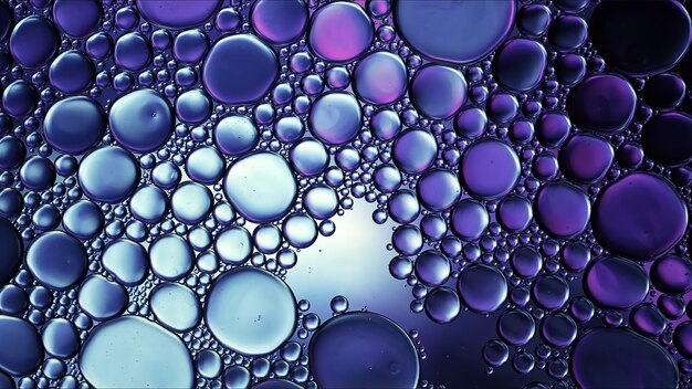 Абстрактные красочные пищевые масла падают пузыри и сферы текут по поверхности воды макросъемки