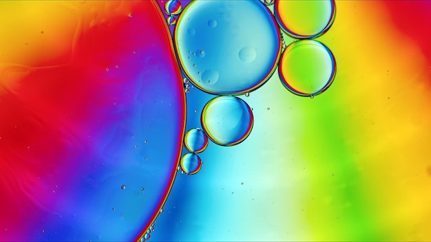 Abstract colorful food oil drops bubbles and spheres flowing on water surface macro photography