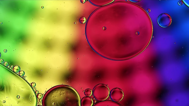 Abstract colorful food oil drops bubbles and spheres flowing on water surface macro photography