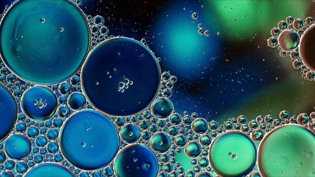 Abstract colorful food oil drops bubbles and spheres flowing on water surface macro photography