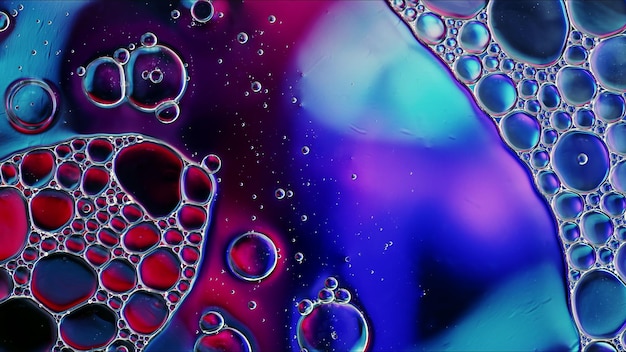 Abstract colorful food oil drops bubbles and spheres flowing on water surface macro photography