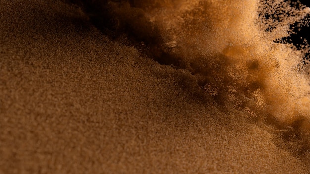 Abstract concept Bronze sand cover blown off on a black isolated background Airflow Grains of sand Slow motion