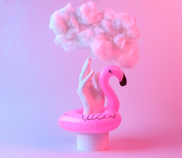 Abstract creative composition of inflatable flamingo hand and soaring cloud in red blue neon light Minimalism