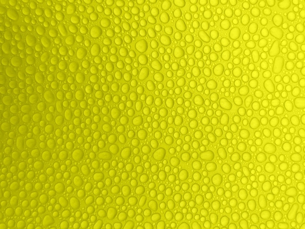 黄色の背景に抽象的な水滴。雨滴。
