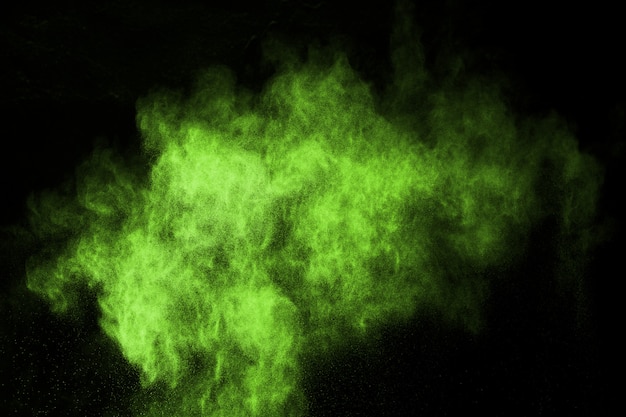 Photo abstract dust explosion frozen green on black background.