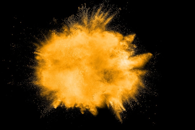 Photo abstract explosion of orange dust on white background. freeze motion of orange dust splashing.