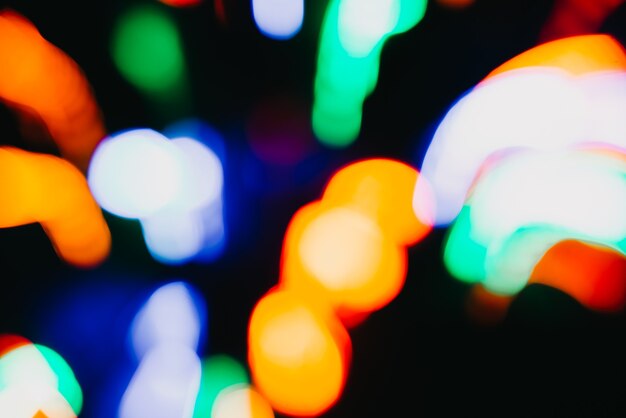 Abstract festive colorful design, multicolored lights in motion blur, futuristic bokeh backdrop on dark background