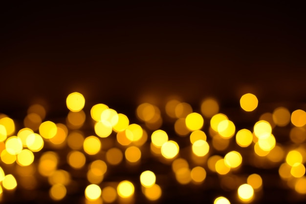 Abstract festive modern background glowing golden blurred bokeh on a black background party time