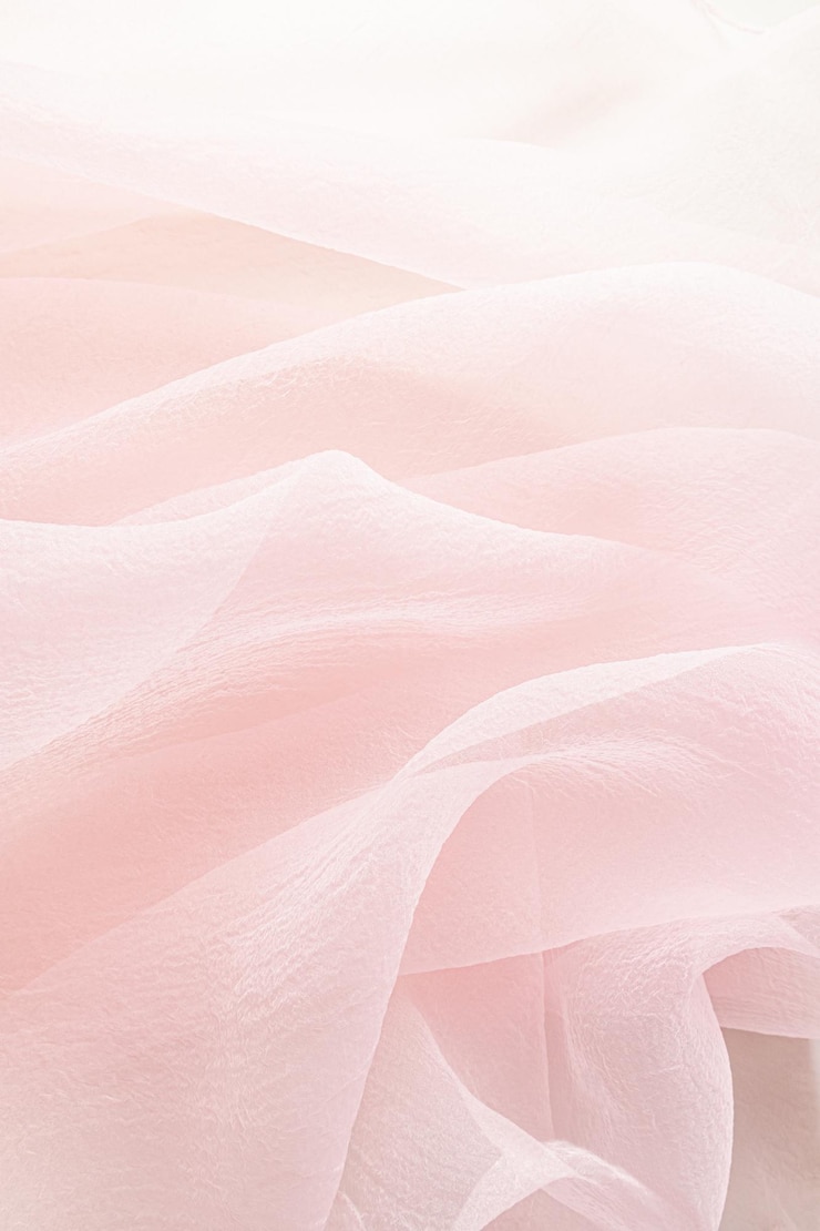 Photo abstract festive wedding background with soft waves of chiffon fabric delicate pastel beige pink background the texture of silk fabric vertical