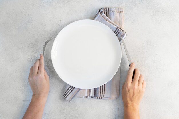 Abstract food background empy white plate with someones hands holding cutlery