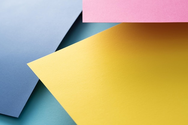 Abstract geometric paper background layout of yellow blue pink sheets with empty space