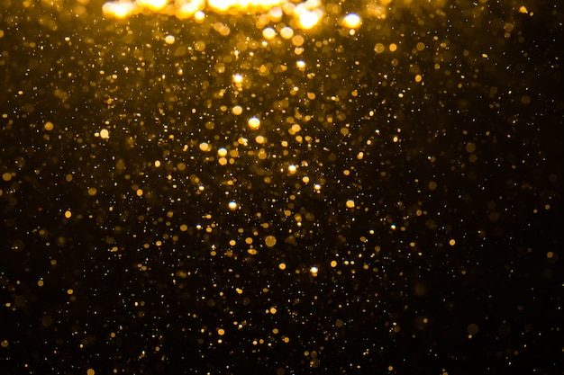 Bokeh astratto dell'oro con priorità bassa nera