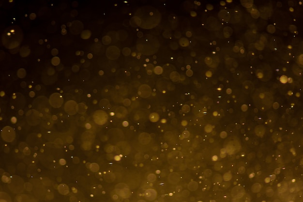 Photo abstract gold bokeh with black background.