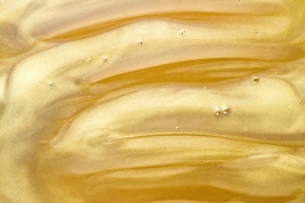 Abstract golden liquid background paint splash swirl pattern and water drops beauty gel and cosmetic...