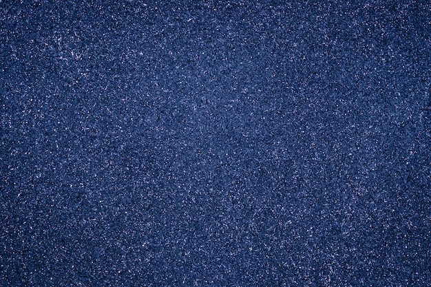 Photo abstract grain background, dark blue granular texture. grunge wall shiny surface.