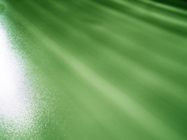 抽象的な緑の背景 ドットがちらつく光線 左上から右下への線とストライプ 斜めの平行で非対称の線 ストライプの光線とビーム