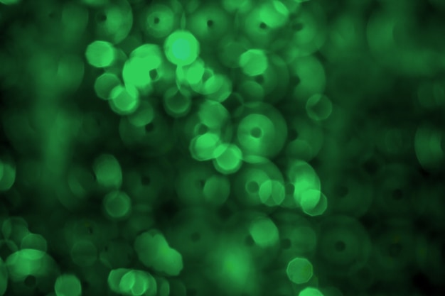 写真 抽象的な緑のバックライト反射板とキラキラボケライトの背景。画像がぼやけている..