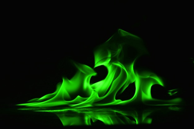 Photo abstract green fire flames on black background